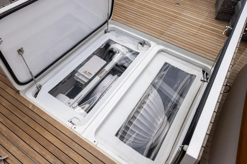 Slide: The Image of 2020 Viking 80 Convertible yacht engine compartment with open hatch on teak deck. - 51