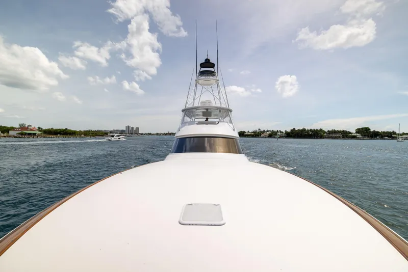 Slide: The Image of 2020 Viking 80 Convertible yacht cruising on a sunny day, showcasing sleek design and open water. - 52