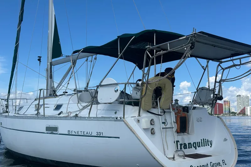 Slide: The Image of 2003 Beneteau Oceanis Clipper 331 sailboat on water, clear sky background. - 11