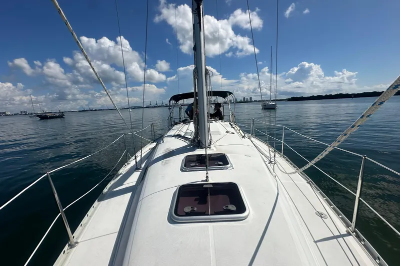 Slide: The Image of 2003 Beneteau Oceanis Clipper 331 sailboat on calm water under a clear blue sky. - 13