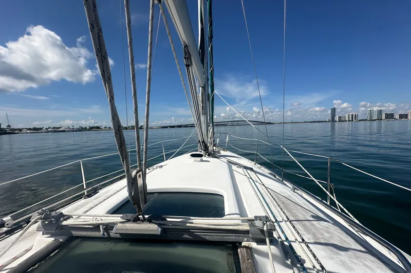 Slide: The Image of 2003 Beneteau Oceanis Clipper 331 sailboat on calm waters with city skyline. - 17