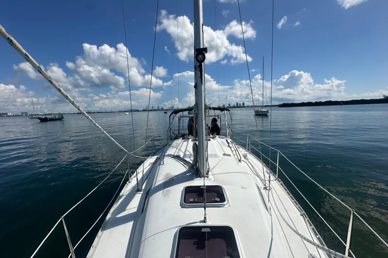 Slide: The Image of 2003 Beneteau Oceanis Clipper 331 sailboat on calm water under a clear blue sky. - 19