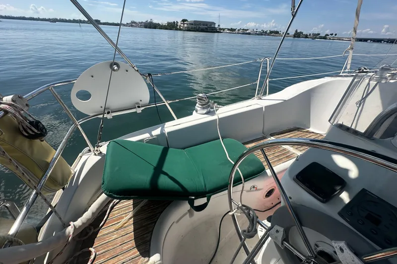 Slide: The Image of Cockpit of 2003 Beneteau Oceanis Clipper 331 sailboat with green cushion and steering wheel. - 28