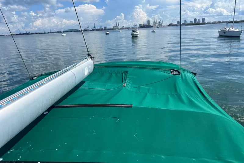 Slide: The Image of Beneteau Oceanis Clipper 331 sailboat with green cover on calm water, 2003 model. - 31