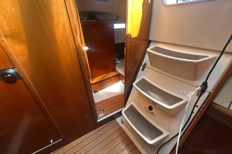 Slide: The Image of Interior of 2003 Beneteau Oceanis Clipper 331 sailboat, featuring wooden cabinetry and steps. - 36