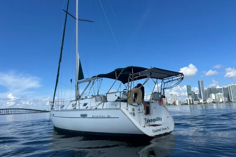 Slide: The Image of 2003 Beneteau Oceanis Clipper 331 sailboat on calm water with city skyline background. - 4