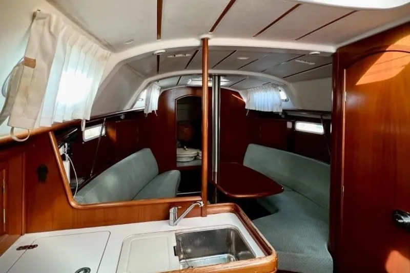Slide: The Image of Interior of 2003 Beneteau Oceanis Clipper 331 sailboat, featuring wood finish and seating area. - 43