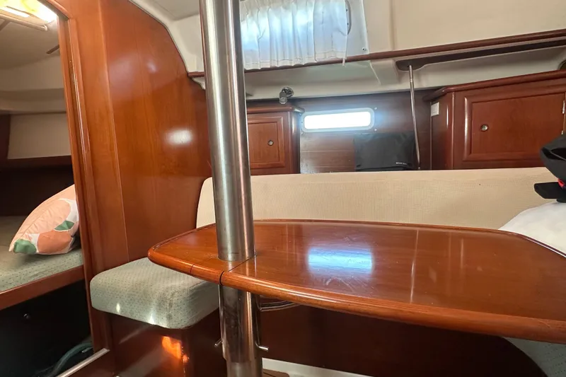 Slide: The Image of 2003 Beneteau Oceanis Clipper 331 interior with wooden table and seating area. - 45