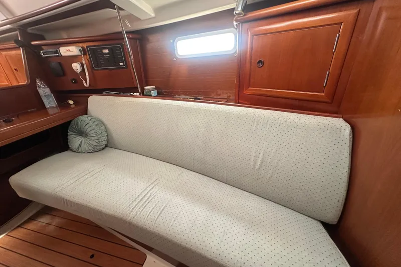 Slide: The Image of Interior of 2003 Beneteau Oceanis Clipper 331 with cushioned seating and wooden cabinetry. - 47
