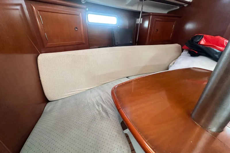 Slide: The Image of Interior of 2003 Beneteau Oceanis Clipper 331 sailboat with wooden table and seating area. - 48