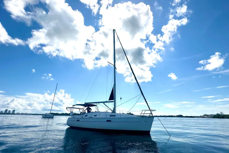 Slide: The Image of 2003 Beneteau Oceanis Clipper 331 sailboat on calm water under a bright blue sky. - 5
