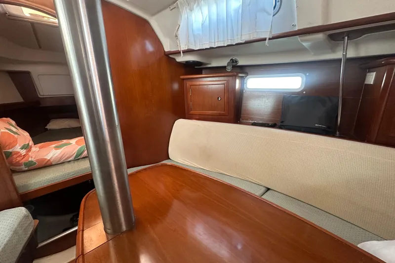 Slide: The Image of Interior of 2003 Beneteau Oceanis Clipper 331 sailboat with wood finish and cozy seating. - 52