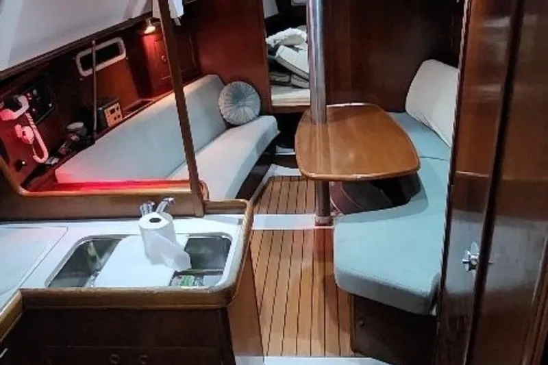 Slide: The Image of Interior of 2003 Beneteau Oceanis Clipper 331 yacht with cozy seating and wooden finishes. - 56