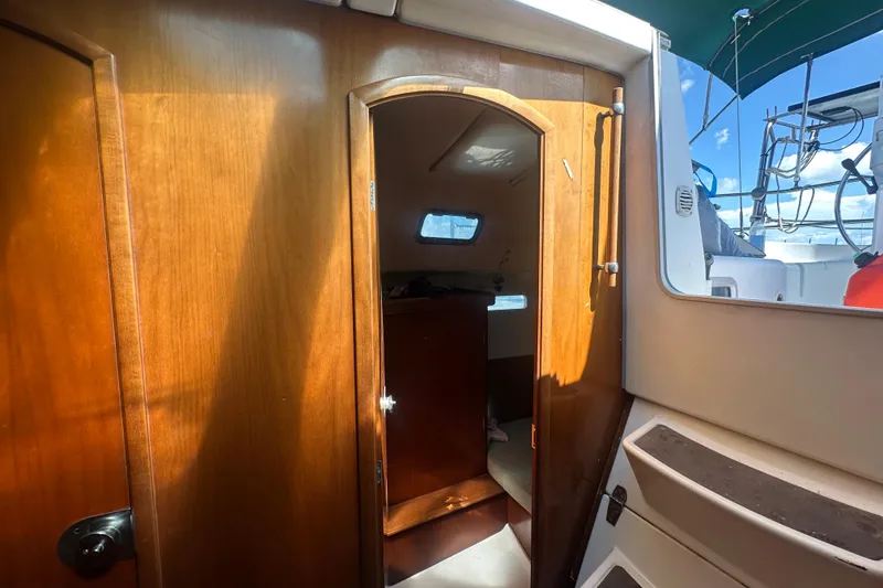 Slide: The Image of Interior view of 2003 Beneteau Oceanis Clipper 331 sailboat, featuring wooden cabin door. - 60