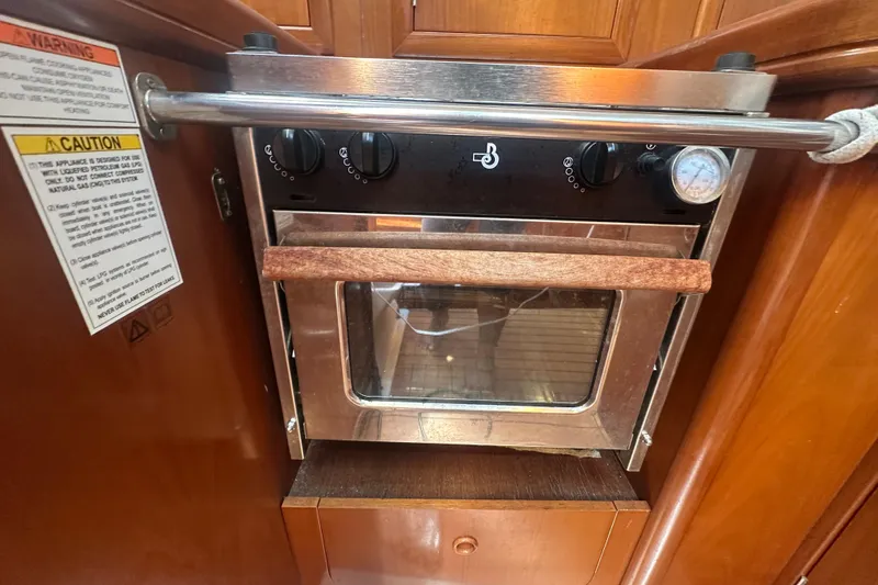 Slide: The Image of 2003 Beneteau Oceanis Clipper 331 yacht kitchen oven with safety warnings. - 70