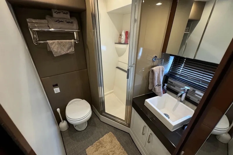 Slide: The Image of 2017 Carver C40 Command Bridge bathroom with shower, sink, and toilet, featuring modern amenities. - 11
