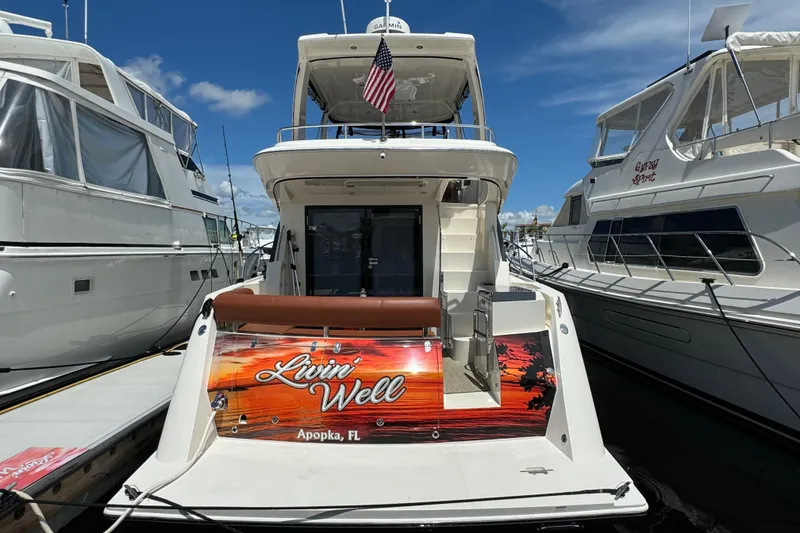 Slide: The Image of 2017 Carver C40 Command Bridge yacht docked, featuring "Livin' Well" signage, Apopka, FL. - 4