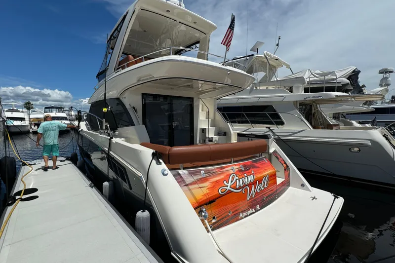 Slide: The Image of 2017 Carver C40 Command Bridge yacht docked, featuring "Livin' Well" signage, Apopka, FL. - 5