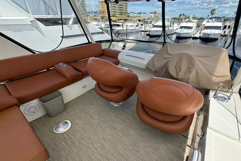 Slide: The Image of Luxurious 2017 Carver C40 Command Bridge yacht interior with brown leather seating at marina. - 8