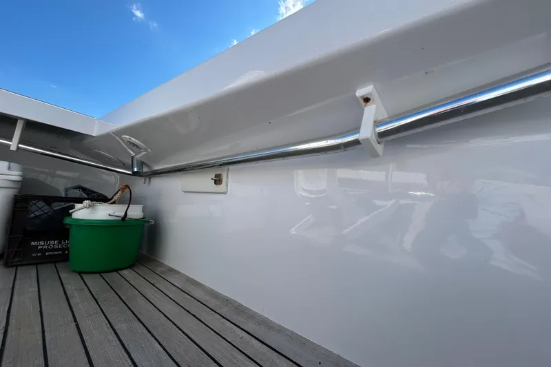Slide: The Image of 1995 Holland Pettegrow Cruiser deck with railing and storage items under blue sky. - 11