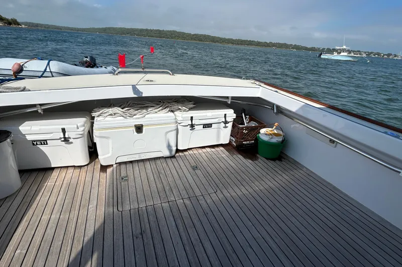 Slide: The Image of 1995 Holland Pettegrow Cruiser deck with coolers, docked on a scenic lake. - 12