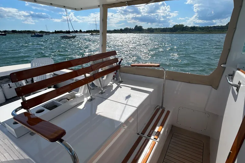 Slide: The Image of 1995 Holland Pettegrow Cruiser interior with wooden seating, overlooking a scenic water view. - 18