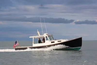Slide: The Image of 1995 Holland Pettegrow Cruiser on calm waters with American flag. - 21