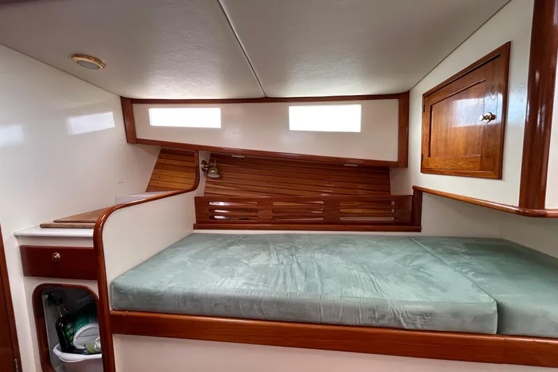 Slide: The Image of Cozy cabin interior of 1995 Holland Pettegrow Cruiser with wooden accents and cushioned bed. - 24