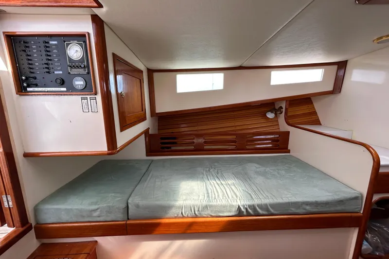 Slide: The Image of Interior of 1995 Holland Pettegrow Cruiser with bed, control panel, and wooden accents. - 26