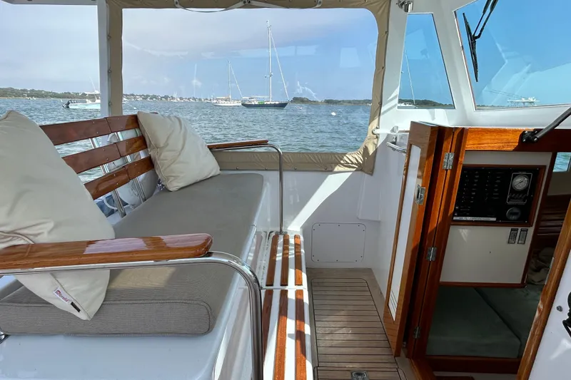 Slide: The Image of Interior of 1995 Holland Pettegrow Cruiser with wooden seating and scenic water view. - 28