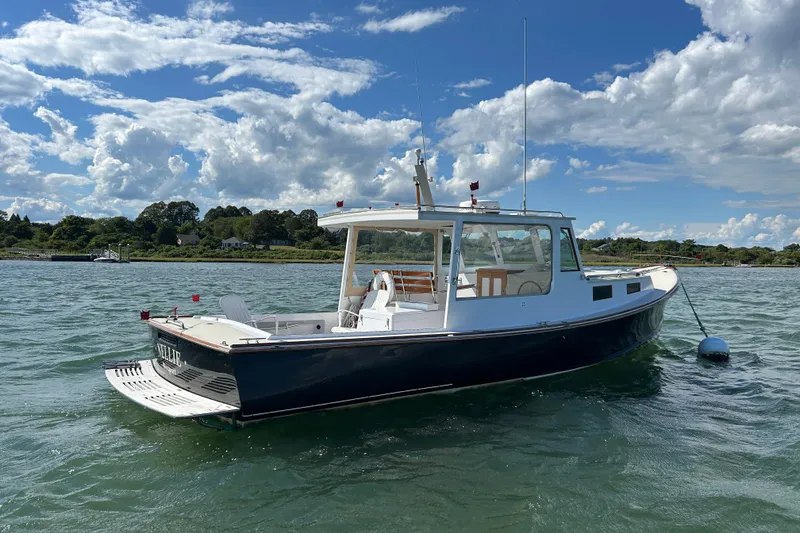 Slide: The Image of 1995 Holland Pettegrow Cruiser on water, blue sky, scenic background. - 3