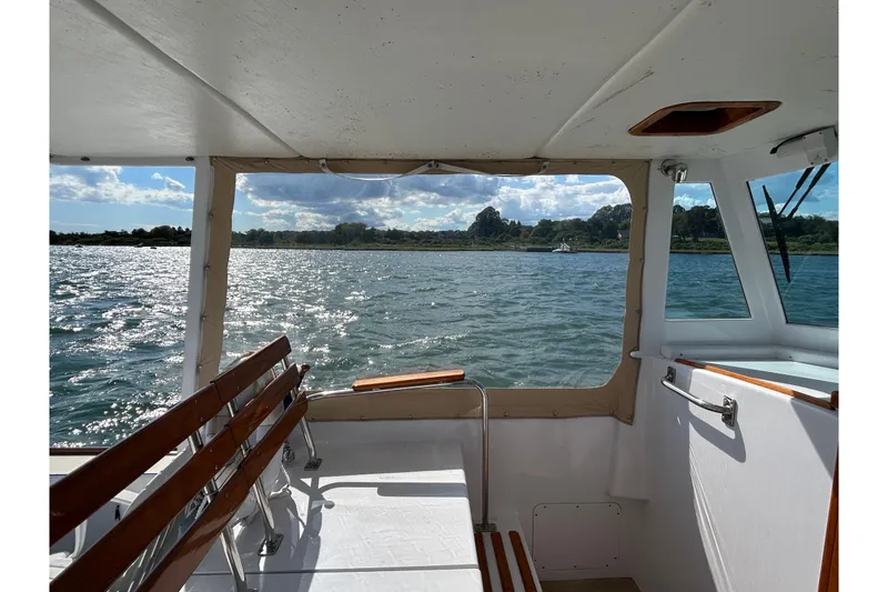 Slide: The Image of 1995 Holland Pettegrow Cruiser interior with scenic water view and wooden seating. - 33