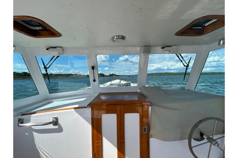 Slide: The Image of Interior view of 1995 Holland Pettegrow Cruiser, showcasing helm and scenic waterway. - 34