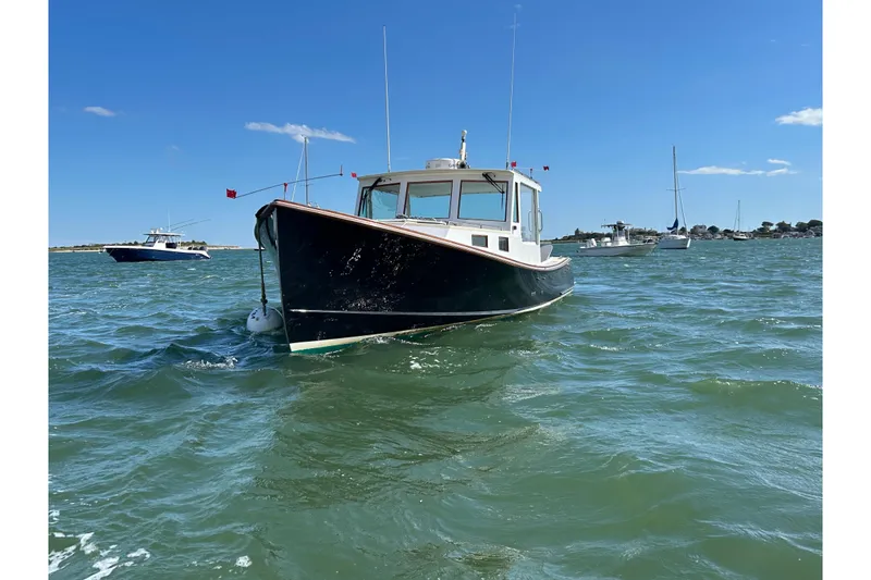 Slide: The Image of 1995 Holland Pettegrow Cruiser on water, clear sky, other boats in background. - 37