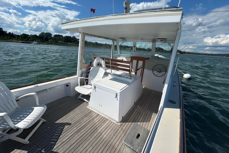 Slide: The Image of 1995 Holland Pettegrow Cruiser on water, featuring deck chairs and steering wheel. - 4