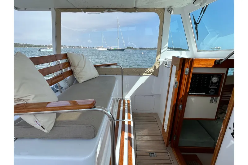 Slide: The Image of Interior of a 1995 Holland Pettegrow Cruiser with wooden seating and scenic water view. - 9