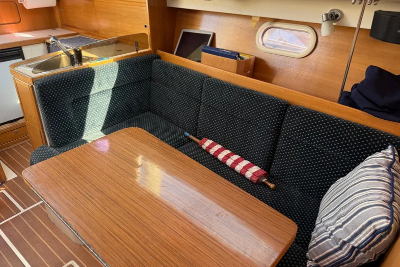 Slide: The Image of Interior of 2008 Catalina 310 sailboat with cozy seating and wooden table. - 10