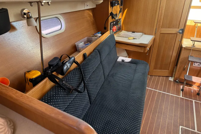 Slide: The Image of 2008 Catalina 310 yacht interior with cushioned seating and navigation equipment. - 11
