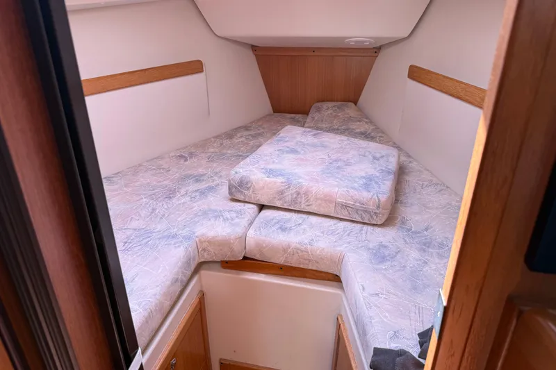 Slide: The Image of 2008 Catalina 310 boat interior with cozy V-berth and patterned cushions. - 13