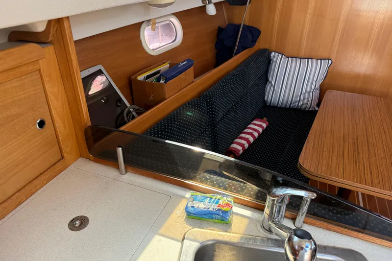 Slide: The Image of Interior of 2008 Catalina 310 sailboat with cozy seating and wooden table. - 18
