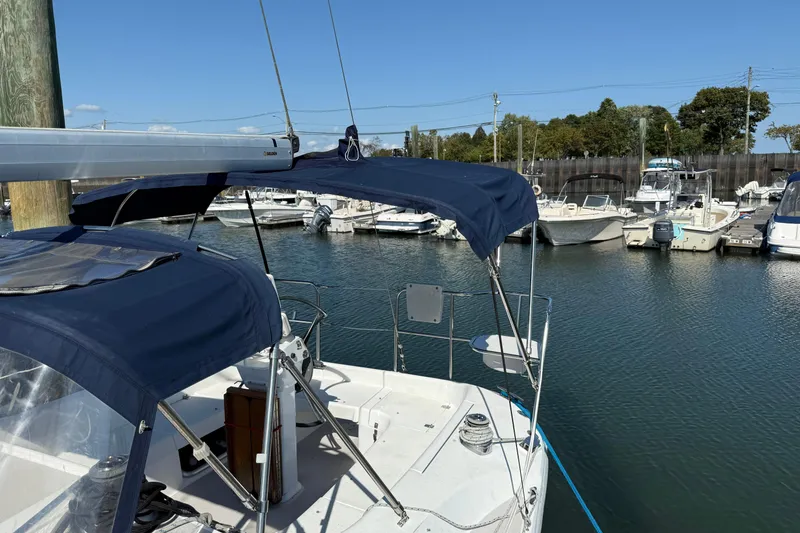 Slide: The Image of 2008 Catalina 310 sailboat docked in marina, featuring blue canopy and clear skies. - 5