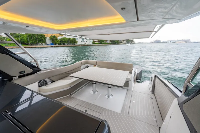 Slide: The Image of Luxurious 2021 Azimut Verve 47 yacht deck with seating and table, overlooking serene waters. - 9