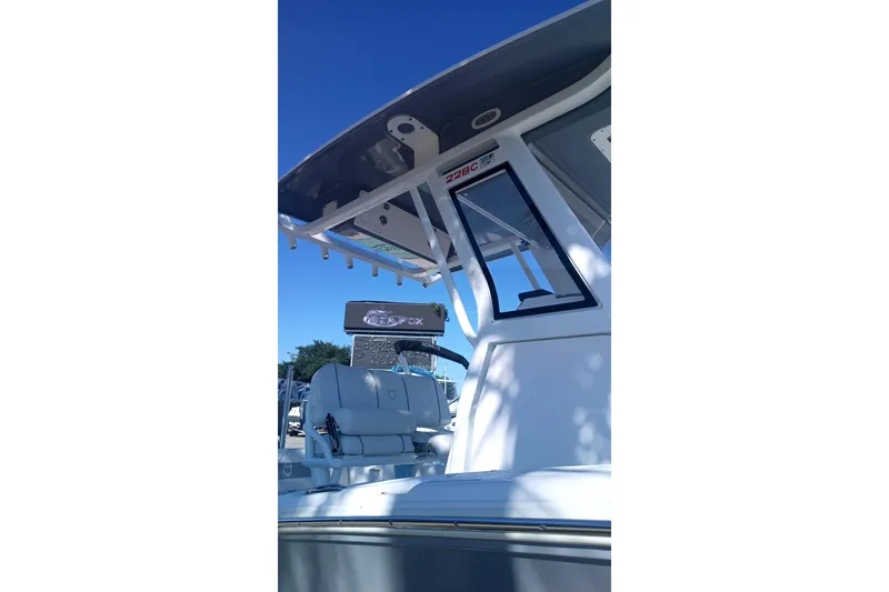 Slide: The Image of 2025 Seafox 228 Commander boat with T-top and seating, under clear blue sky. - 9