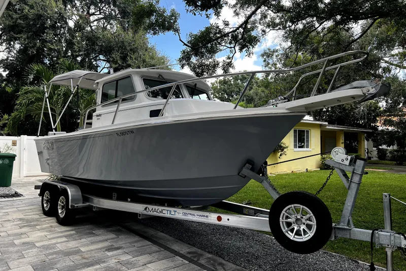 Slide: The Image of 2023 Parker 2120 Sport Cabin boat on trailer, parked in residential driveway. - 0