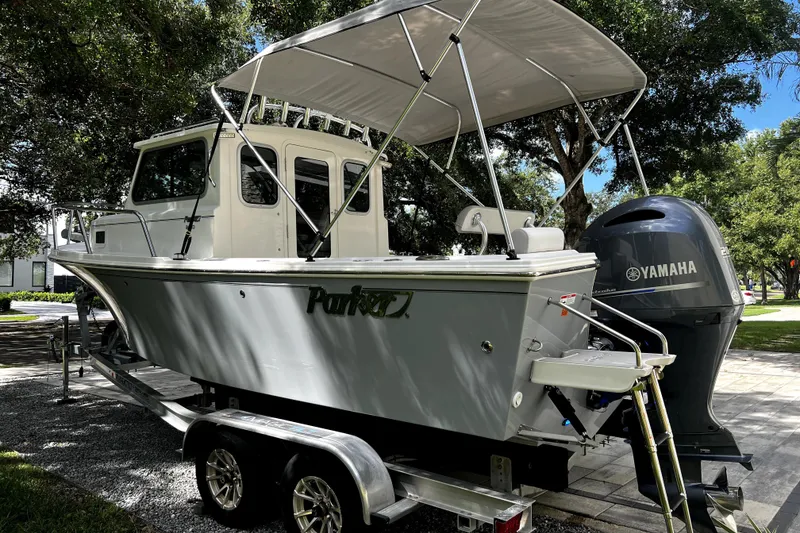 Slide: The Image of 2023 Parker 2120 Sport Cabin boat with Yamaha engine on trailer, parked outdoors. - 10