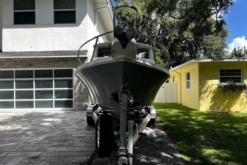 Slide: The Image of 2023 Parker 2120 Sport Cabin boat on trailer in residential driveway. - 14