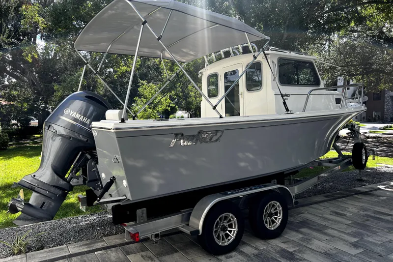 Slide: The Image of 2023 Parker 2120 Sport Cabin boat on trailer with Yamaha outboard motor. - 2