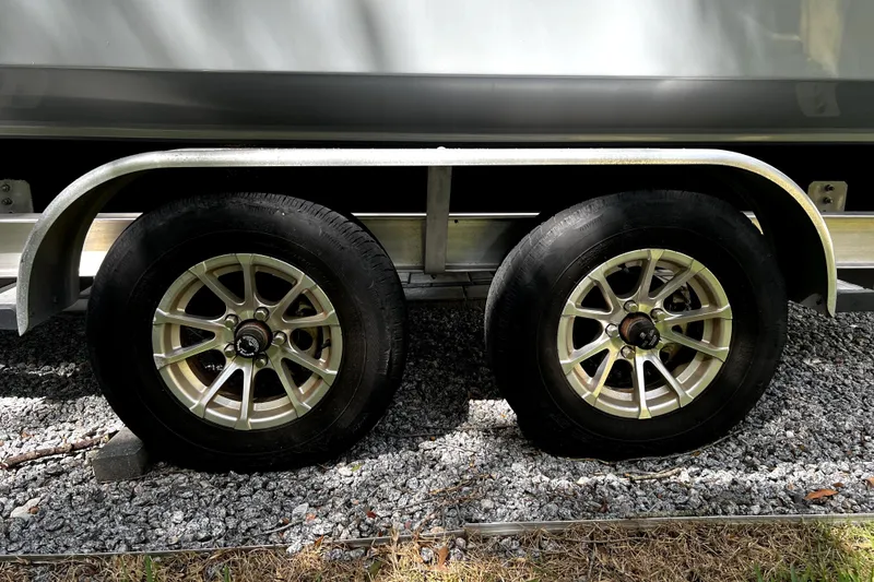 Slide: The Image of Trailer wheels of a 2023 Parker 2120 Sport Cabin boat on gravel. - 20