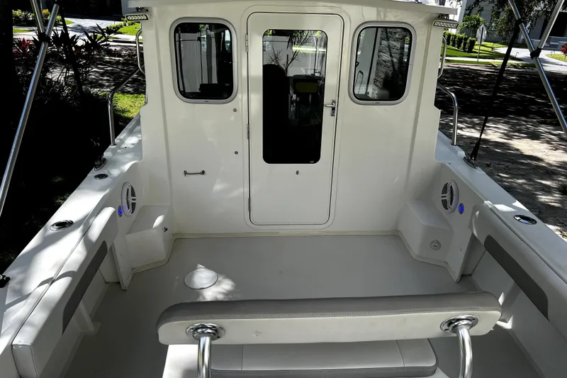 Slide: The Image of 2023 Parker 2120 Sport Cabin boat interior with seating and cabin door. - 23