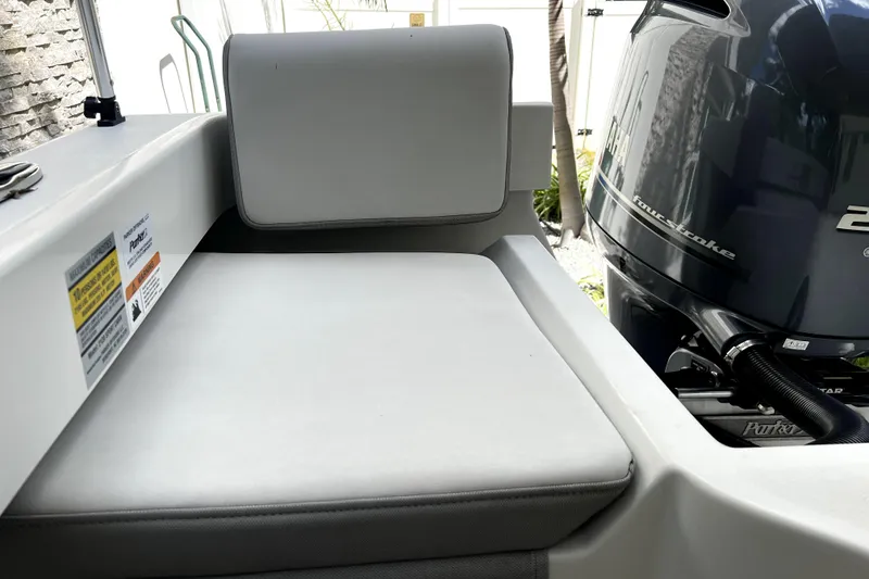 Slide: The Image of 2023 Parker 2120 Sport Cabin boat interior with cushioned seating and outboard motor. - 32